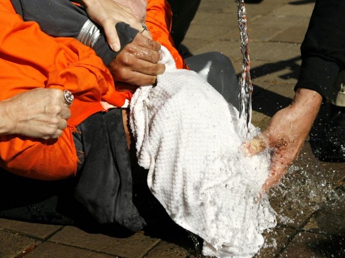 Demonstrator Maboud Ebrahimzadeh is held down during a simulation of waterboarding outside the Justice Department in Washington in this November 5, 2007 file photo. The possibility that U.S. spies located Osama bin Laden with help from detainees who'd been subjected to "enhanced interrogation" techniques seems certain to reopen the debate over practices that many have equated with torture, security experts said on Monday.