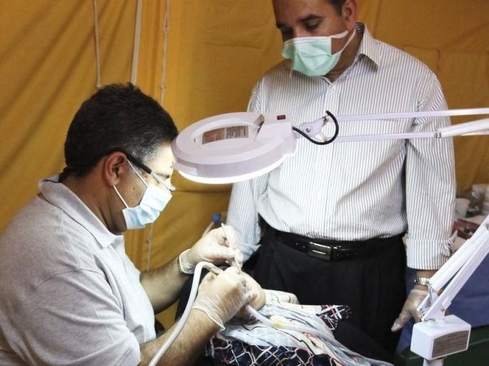 Dentists examine the teeth of a Libyan refugee at a field hospital in a new refugee camp set up by Qatar in Tataouine June 3, 2011.