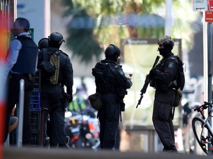 Members of the New South Wales (NSW) Police Force Public Order and Riot Squad (PORS) are seen outside a Lindt cafe in Martin Place in the central business district of Sydney, Australia, 15 December 2014. A number of hostages were being held on 15 December morning inside a central Sydney cafe, after witnesses reported hearing possible gunshots. At least three people could be seen holding their hands up inside the establishment, and an Islamist flag was hanging in the window. Dozens of police were at the scene. The standoff followed news reports that police had arrested a terrorism suspect in western Sydney. The surrounding area has been evacuated. EPA/DAN HIMBRECHTS AUSTRALIA AND NEW ZEALAND OUT