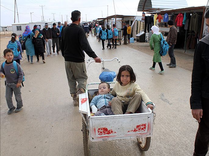 epa04530454 A Syrian man pulls his children sitting in a carriage at the Zattari refugee camp near Mafraq city, Jordan, 15 December 2014. The World Food Programme (WFP) said on 09 December it will be able to resume its food aid for