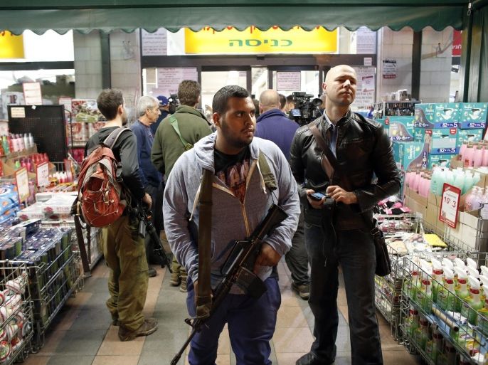 An Israeli security member stands guard at the entrance of a supermarket where a Palestinian teen stabbed two Israelis in 'an apparent terror attack' in the West Bank settlement of Mishor Adumim on December 3, 2014. The Palestinian teen was shot in the leg after the attack by an off-duty security guard, police said. Police spokeswoman Luba Samri said in a statement that the alleged attacker was a 16-year-old from the village of Al-Azariya east of Jerusalem. AFP PHOTO / THOMAS COEX