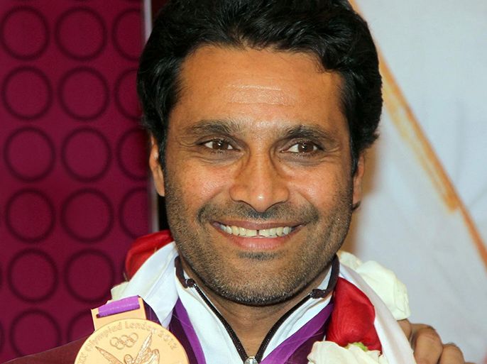 Qatar's Nasser al-Attiyah, medalist in the skeet men's final at the London 2012 Olympic Games poses with his bronze medal upon his arrival back home at Doha's International Airport on August 13, 2012.