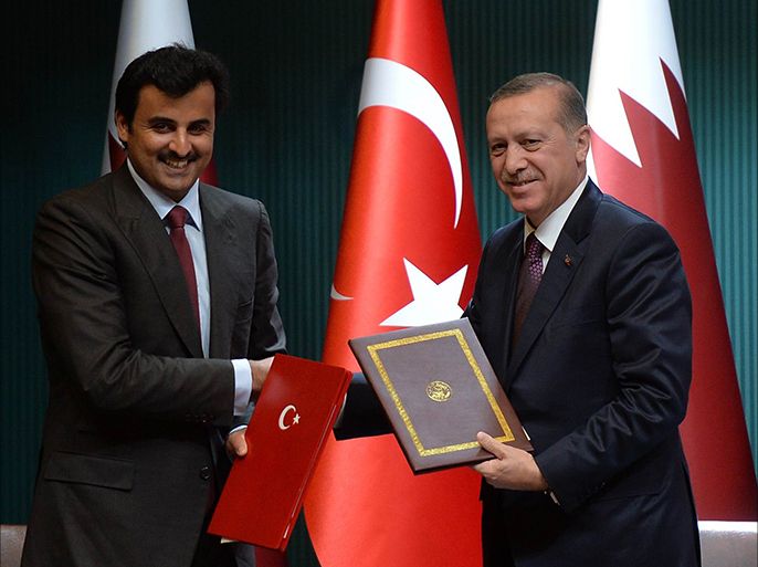 Turkish President Recep Tayyip Erdogan (R) shakes hands with Emir of Qatar Sheikh Tamim bin Hamad bin Khalifa Al Thani (L) after signing a political declaration about High-Level Strategic Cooperation Council during a meeting at the presidential palace in Ankara, on December 19, 2014. AFP PHOTO