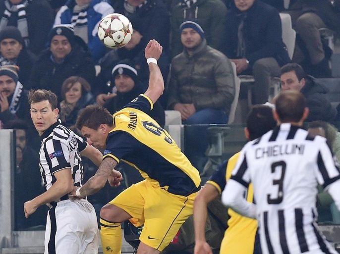 Juventus' Stephan Lichtsteiner (L) and Atletico Madrid's Mario Mandzukic in action during the Uefa Champions League group A soccer match between Juventus FC and Atletico Madrid at the Juventus Stadium in Turin, Italy, 09 December 2014.