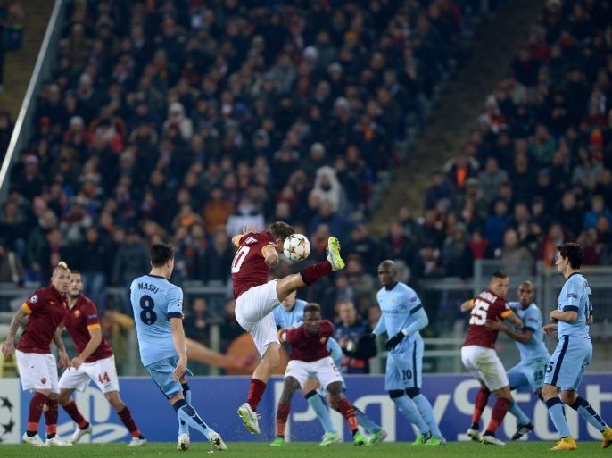 Manchester City's French midfielder Samir Nasri kicks the ball as Roma's forward Francesco Totti jumps during the UEFA Champions League football match AS Roma vs Manchester City on December 10, 2014 at the Olympic stadium in Rome. AFP PHOTO / FILIPPO MONTEFORTE
