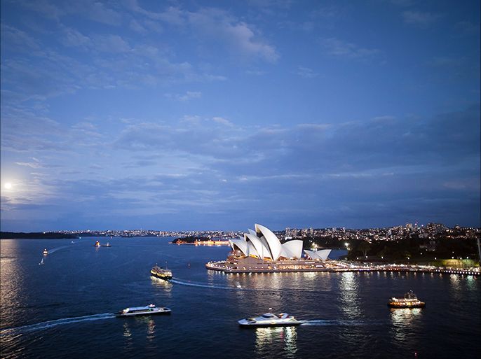 epa04436927 The moon rises behind the Opera House in Sydney, Australia, 08 October 2014. EPA