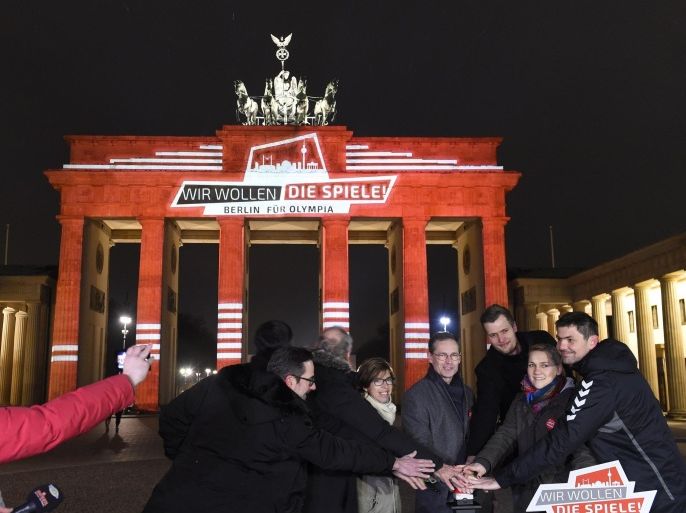 Berlin governing mayor Michael Mueller (4thR) and representatives of politics and sports organisations press a button in front of the illuminated Brandenburg Gate to officially open campaign for the bid of Berlin to host the 2024 or 2028 Summer Olympic and Paralympic games, on January 23, 2015 in Berlin. The illumination on the gate reads : 'We want the games, Berlin for Olympics'. Germany has not hosted an Olympics since tragedy-marred Munich Games in 1972.AFP PHOTO / TOBIAS SCHWARZ