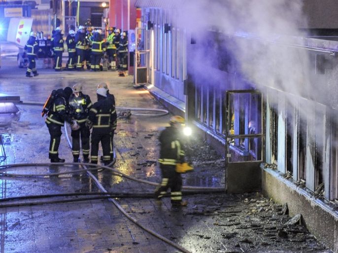 Firemen work outside a still smoking cellar mosque in Eskilstuna, Sweden, Thursday, Dec. 25, 2014. Five of the twenty at prayer inside were taken to hospital after inhaling smoke when a burning object was hurled through a window, setting fire to the building in the early afternoon. (AP Photo/Pontus Stenberg) SWEDEN OUT