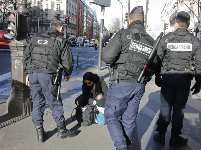 French Gendarmes check a passerby's bag as they secure the access to the solidarity march (Rassemblement Republicain) in the streets of Paris January 11, 2015. French citizens will be joined by dozens of foreign leaders, among them Arab and Muslim representatives, in a march on Sunday in an unprecedented tribute to this week's victims following the shootings by gunmen at the offices of the satirical weekly newspaper Charlie Hebdo, the killing of a police woman in Montrouge, and the hostage taking at a kosher supermarket at the Porte de Vincennes. REUTERS/Eric Gaillard (FRANCE - Tags: CRIME LAW POLITICS CIVIL UNREST SOCIETY)