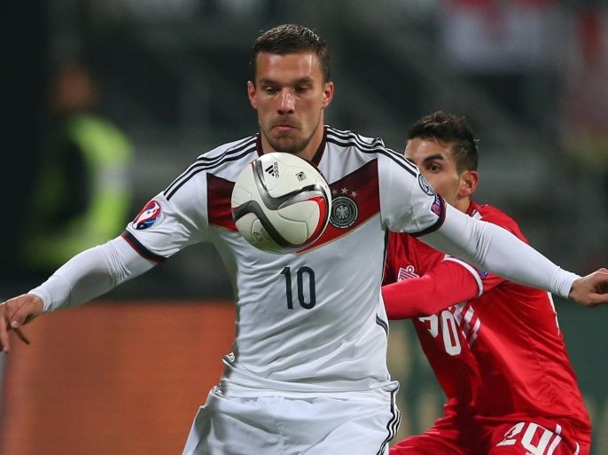 NUREMBERG, GERMANY - NOVEMBER 14: Lukas Podolski (L) of Germany battles for the ball with Jean Carlos Garcia of Gibraltar during the EURO 2016 Group D Qualifier match between Germany and Gibraltar at Grundig Stadion on November 14, 2014 in Nuremberg, Germany.