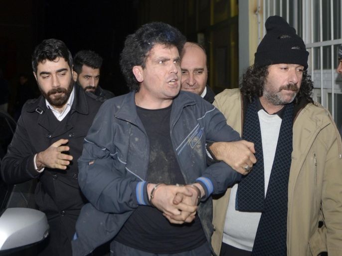ISTANBUL, TURKEY - JANUARY 01: Firat Ozcelik (C), detained Thursday while he was throwing a hand grenade at a police booth in front of the historic Dolmabahce Palace located just minutes away from Turkish prime ministers Istanbul office, is seen with undercover police officers in Istanbul, Turkey on January 01, 2015.