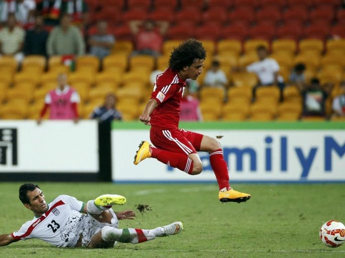 Iran's Mehrdad Pooladi (R) jumps as UAE's Omar Abdulrahman tackles during their Asian Cup Group C soccer match at the Brisbane Stadium in Brisbane January 19, 2015. REUTERS/Edgar Su (AUSTRALIA - Tags: SOCCER SPORT)