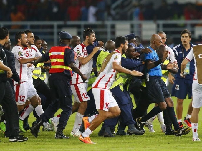 Referee Rajindraparsad Seechurn is escorted from the pitch by security officers after quarter-final soccer match of the 2015 African Cup of Nations between Tunisia and Equatorial Guinea in Bata, January 31, 2015. REUTERS/Mike Hutchings (EQUATORIAL GUINEA - Tags: SPORT SOCCER)