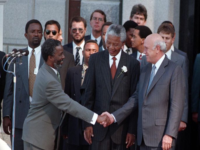 PRETORIA, SOUTH AFRICA - MAY 10: FILE: Nelson Mandela, the newly elected president of the Republic of South Africa, smiles as his Vice-Presidential running mate Thabo Mbeki shakes hands with outgoing president F.W. de Klerk at the start of Mandela's inaugural ceremony in Pretoria, South Africa on May 10, 1994. de Klerk was credited with helping to bring the system of Apartheid to an end by negotiating a transition to majority rule in the country.