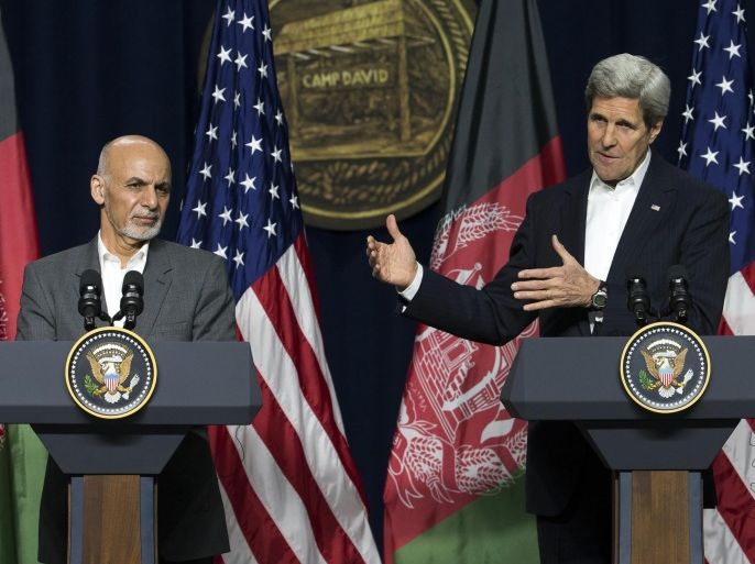Afghan President Ashraf Ghani, left, looks on as Secretary of State John Kerry delivers remarks during a news conference at Camp David Presidential retreat, on Monday, March 23, 2015, in Camp David, Md. The pace of U.S. troop withdrawals from Afghanistan will headline Afghan President Ashraf Ghani's visit to Washington, yet America's exit from the war remains tightly hinged to the abilities of the Afghan forces that face a tough fight against insurgents this spring. (AP Photo/ Evan Vucci)