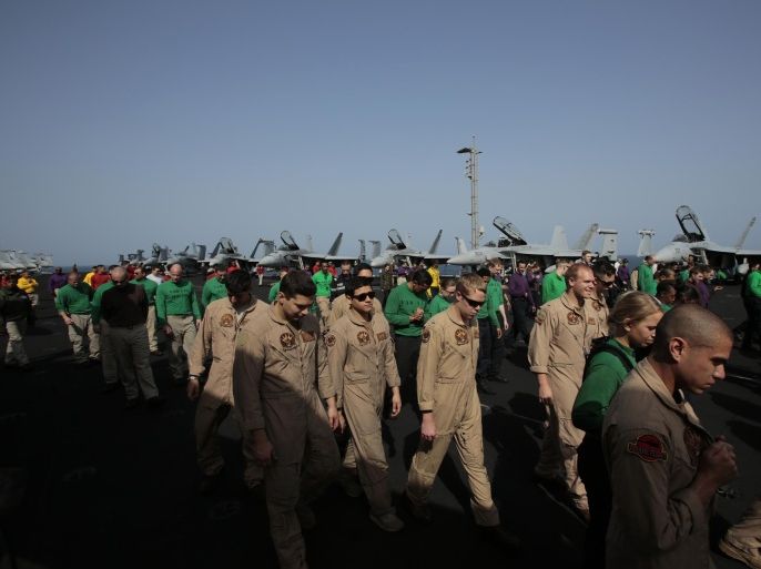 U.S. sailors and pilots walk on the flight deck, checking for any debris, aboard the USS Carl Vinson aircraft carrier in the Persian Gulf, Thursday, March 19, 2015. U.S. aircraft aboard the Carl Vinson as well as French military jets aboard the nearby French carrier Charles de Gaulle are flying missions over Iraq in the fight against Islamic State militants. (AP Photo/Hasan Jamali)