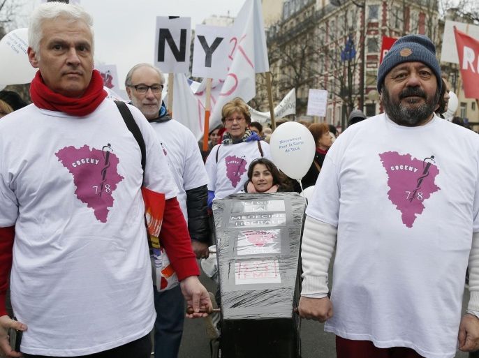 French healthcare professionals carry a mock coffin as doctors, medical students, hospital interns and doctors shout attend a national demonstration in Paris March 15, 2015. Thousands of French healthcare professionals protest the new public healthcare bill by the French Health minister. REUTERS/Gonzalo Fuentes (FRANCE - Tags: HEALTH POLITICS)
