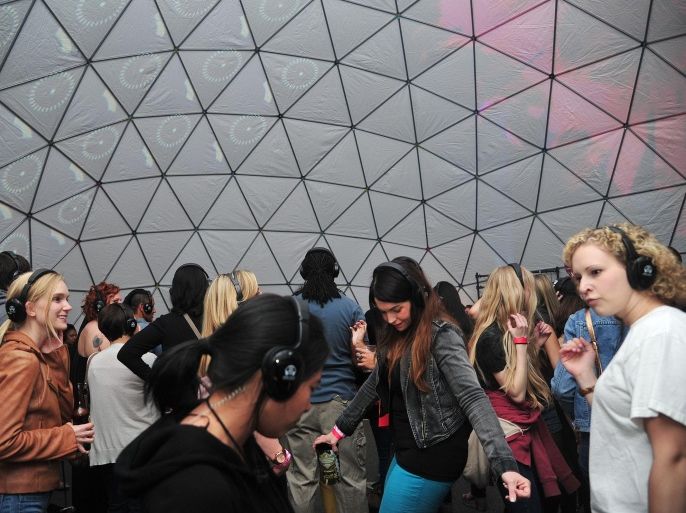 People dance at a silent disco inside the GeoDome at "Paint The Town Red," an annual arts and music festival in downtown Birmingham, Ala., Saturday, April 20, 2013. Paint The Town Red benefits the Jefferson-Shelby County Chapter of the American Red Cross. The silent disco is an immersive way to listen to music broadcast by a DJ over wireless headsets.