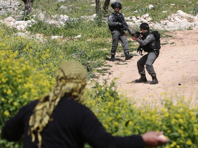 A Palestinian protestor takes position to throw stones towards Israeli security forces during clashes following a weekly demonstration against the expropriation of Palestinian land by Israel in the village of Kfar Qaddum, near Nablus in the occupied West Bank, on March 13, 2015. AFP PHOTO / JAAFAR ASHTIYEH