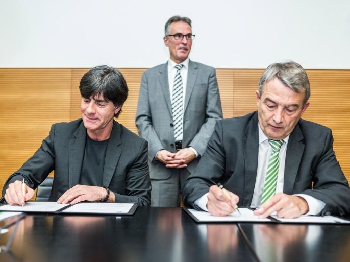 FRANKFURT AM MAIN, GERMANY - MARCH 13: Joachim Loew, head coach of the German national football team (L), and DFB President Wolfgang Niersbach (R) sign the new contract for Loew and his training team during a DFB Executive Board Meeting at DFB Headquarters on March 13, 2015 in Frankfurt am Main, Germany.