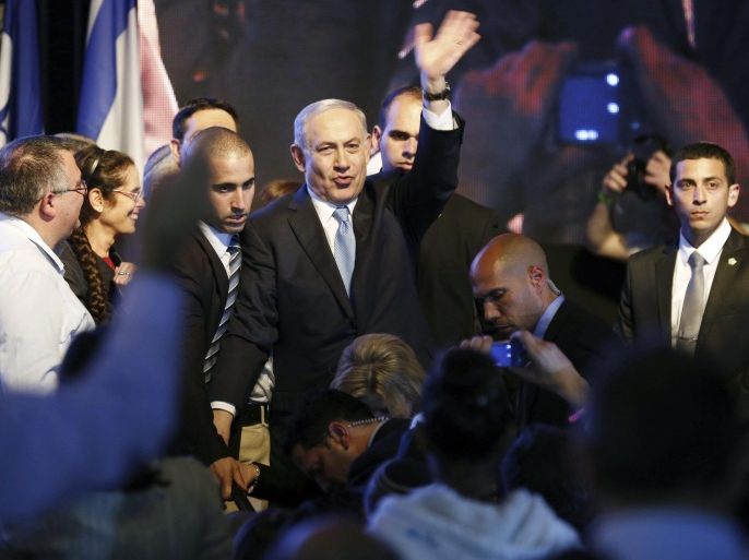 Israeli Prime Minister Benjamin Netanyahu (C) waves to supporters at party headquarters in Tel Aviv March 18, 2015. Netanyahu claimed victory in Israel's election after exit polls showed he had erased his center-left rivals' lead with a hard rightward shift in which he abandoned a commitment to negotiate a Palestinian state. REUTERS/Amir Cohen (ISRAEL - Tags: POLITICS ELECTIONS)