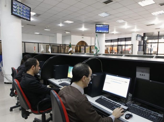 Employees monitor stock trading at the Algeria Stock Exchange in Algiers March 13, 2012. Algeria's stock market has long resembled its economy: overegulated, uncompetitive and performing well short of its potential. So the country's plans to allow foreign money into the market may herald wider economic change. Picture taken March 13, 2012.
