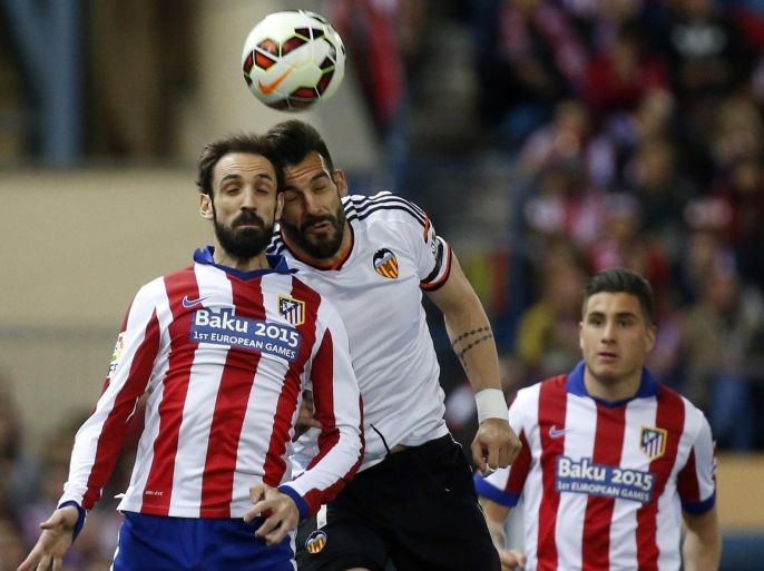 Atletico Madrid's Juanfran (L) jumps for the ball with Valencia's Alvaro Negredo during their Spanish first division soccer match at Vicente Calderon stadium in Madrid March 8, 2015. REUTERS/Juan Medina (SPAIN - Tags: SPORT SOCCER)