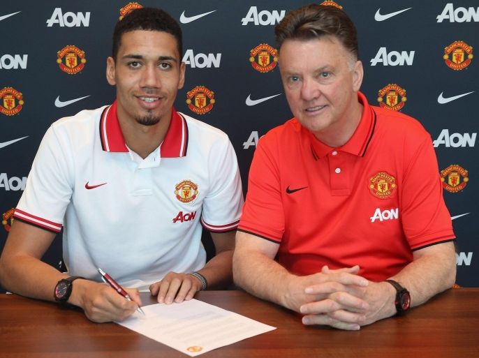 MANCHESTER, ENGLAND - APRIL 21: (EXCLUSIVE COVERAGE) Chris Smalling of Manchester United (L) poses with manager Louis van Gaal after signing a contract extension at Aon Training Complex on April 21, 2015 in Manchester, England.