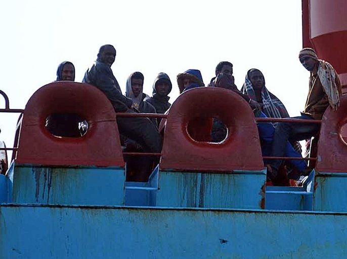Immigrants stand on April 15, 2015 on the deck of a boat as they arrive in the Italian port of Messina in Sicily. Up to 400 illegal migrants died after their vessel capsized off the Libyan coast on April 12, said survivors who were brought to Italy, where tension is mounting over a surge in boat arrivals from North Africa. AFP PHOTO / GIOVANNI ISOLINO