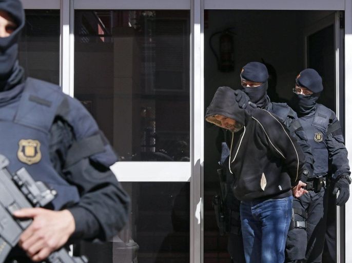 Catalonian regional policemen escort one of the ten men who were arrested during an operation against the Jihadist terrorism carried out in the region of Catalonia, northeastern Spain, 08 April 2015. The ten suspects are accused of being members of a terrorist organisation linked with the Islamic State (IS), police sources said.