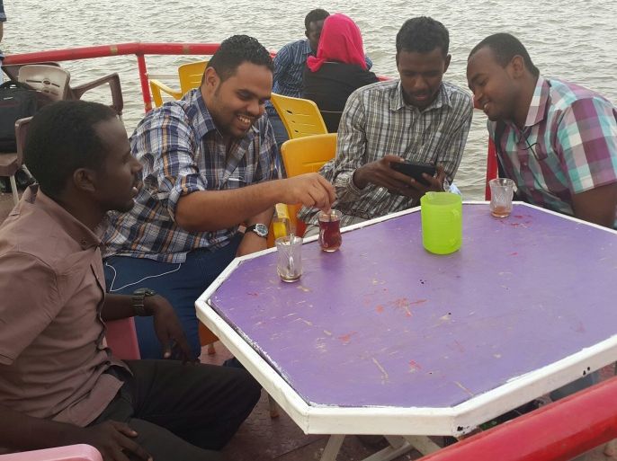 مجموعة من الشباب السوداني على مركب ثابت على النيل الأزرق يحتسو ن الشاي (الجزيرة نت)