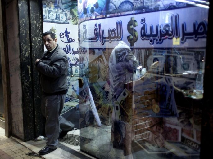 An Egyptian man leaves after changing foreign currency at a currency exchange office, Arabic reads, "Arabian Egypt for Exchange," in Cairo, Egypt, Sunday, Jan. 6, 2013. Egypt swore in 10 new ministers on Sunday in a Cabinet shake-up aimed at improving the government's handling of the country's ailing economy ahead of talks this week with the International Monetary Fund over a badly needed $4.8 billion loan.