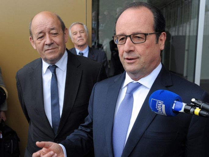 French president François Hollande (R) flanked by minister of defence Jean-Yves Le Drian talks to journalists on April 30, 2015 during a visit to a new apprentice training center in Guipavas near Brest, western France as Hollande announced on April 19 measures to promote the aprenticeship contracts in the small companies, to encourage the youth employment. Hollande vowed to 'show no mercy' if peacekeeping troops in the Central African Republic accused of raping starving children in exchange for food were found guilty. AFP PHOTO FRED TANNEAU
