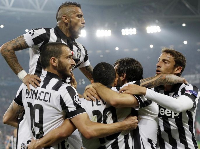 Juventus' Carlos Tevez, third from left, celebrates with his teammates, from left, Arturo Vidal, top, Leonardo Bonucci, Andrea Pirlo and Claudio Marchisio after scoring, during the Champions League, semifinal soccer match between Juventus and Real Madrid at the Juventus Stadium in Turin, Italy, Tuesday, May 5, 2015. Juventus won 2-1. (AP Photo/Luca Bruno)