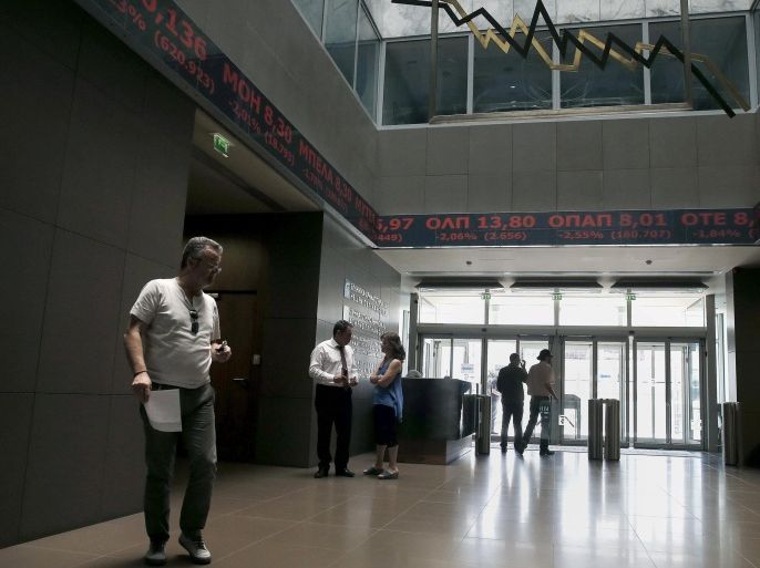 People walk inside the Athens stock exchange as a stock ticker shows stock options making losses, June 12, 2015. Greece on Friday said the International Monetary Fund's decision to leave negotiations on a cash-for-reforms deal in Brussels was designed to put pressure on both Athens and its European creditors. REUTERS/Alkis Konstantinidis