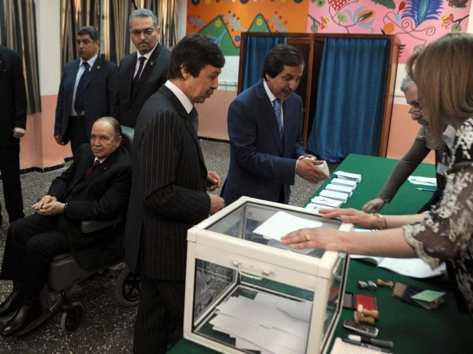 Algeria's ailing President Abdelaziz Bouteflika running for re-election, watches after casting his ballot from a wheelchair as his brothers Said (L), who serves as special adviser, and Nasser (R) vote at a polling station in Algiers on April 17, 2014. Algerians were voting in presidential elections, with Bouteflika widely expected to win a fourth term despite chronic health problems, fraud warnings and calls for a boycott. AFP PHOTO / FAROUK BATICHE