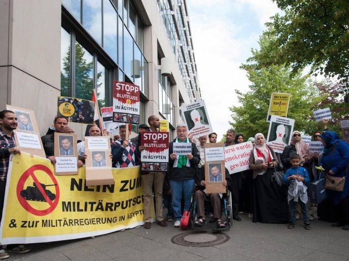 Demonstraters hold placards outside a police station, Berlin, Germany 21 June 2015. A protest of about 60 people calling for the release of Al Jazeera journalist Ahmed Mansour had gathered. The journalist was arrested on 20 June at Berlin-Tegel Airport when he tried to fly to Doha, Qatar. According to the German Federal Police an international arrest warrant was out against him, which had been sent to them. Mansour is one of the most famous television journalists in the Arab world. In 2014 criminal court in Cairo had sentenced him in absentia to 15 years in prison because he allegedly participated in the torture of a lawyer the Arab spring movment of 2011.
