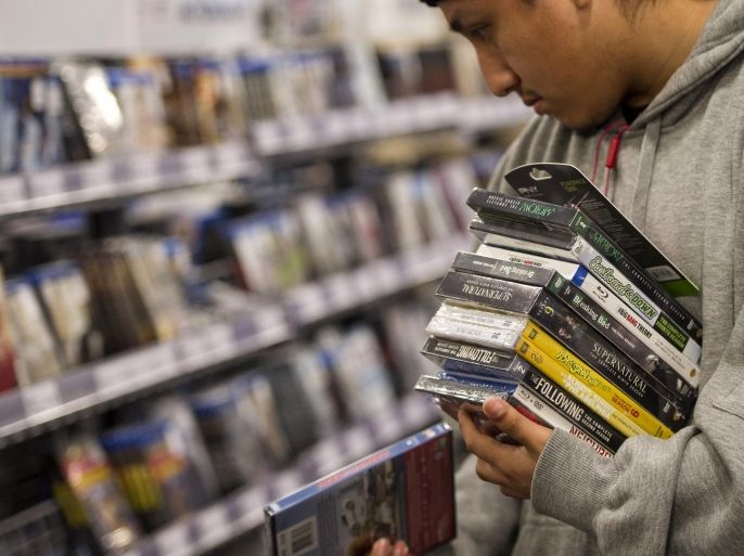 A customer browses DVD's on sale at a Best Buy Co. store ahead of Black Friday in San Francisco, California, U.S., on Thursday, Nov. 27, 2014. An estimated 140 million U.S. shoppers will hit stores and the Web this weekend in search of post-Thanksgiving discounts, kicking off what retailers predict will be the best holiday season in three years.