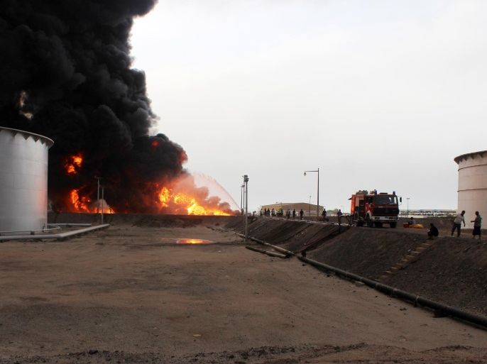 Yemeni fighters of the southern separatist movement and firefighters attempt to extinguish a flame at an oil refinery in the port city of Aden on June 27, 2015, following shelling by Shiite Huthi rebels. Fire erupted at Aden's oil refinery when rebels shelled the nearby port to prevent a Qatari ship carrying aid for Yemen's devastated second city from docking, officials told AFP. AFP PHOTO / SALEH AL-OBEIDI