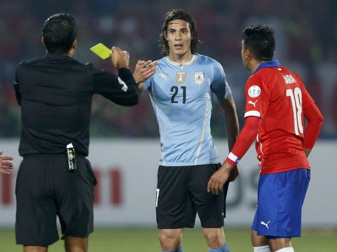 Referee Sandro Ricci shows a second yellow card to Uruguay's Edinson Cavani next to Chile's Gonzalo Jara during their quarter-finals Copa America 2015 soccer match at the National Stadium in Santiago, Chile, June 24, 2015. REUTERS/Ueslei Marcelino