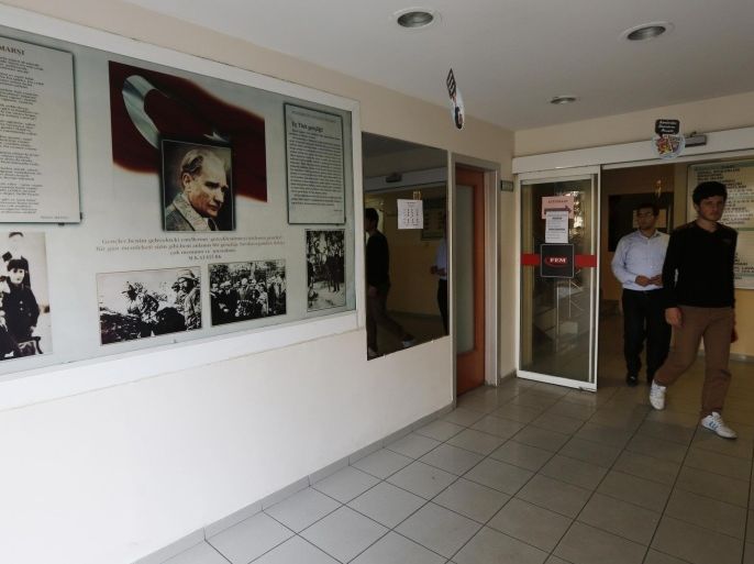 REFILE - ADDING INFORMATIONStudents walk past photographs of modern Turkey's secular founder Mustafa Kemal Ataturk hanging on a wall at the entrance of FEM University Preparation School in Uskudar November 27, 2013. At the FEM University Preparation School in Uskudar, a conservative district on the Asian side of Istanbul, young men are quietly receiving specialised coaching in how to pass the exams that give access to the most important jobs in Turkey. To a casual eye, nothing seems remarkable. As in nearly all Turkish schools, a portrait of Ataturk hangs in every classroom. There are no visible references either to the religious movement which runs the school, known as Hizmet, or "Service" - or to the movement's founder, cleric Fethullah Gulen, based in the United States for 14 years. But the teachers are almost all Gulen followers, as are many of the pupils and their parents. Picture taken November 27, 2013. To match Insight TURKEY-ERDOGAN/GULEN REUTERS/Murad Sezer (TURKEY - Tags: POLITICS RELIGION EDUCATION)