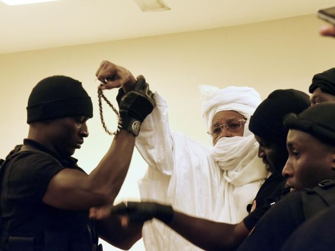 Former Chadian dictator Hissene Habre (C) is escorted by prison guards into the courtroom for the first proceedings of his trial by the Extraordinary African Chambers in Dakar on July 20, 2015. More than a quarter-century after his blood-soaked reign came to an end, former Chadian dictator Hissene Habre went on trial in a Senegalese court on July 20 in what is seen as a test case for African justice. AFP PHOTO / SEYLLOU