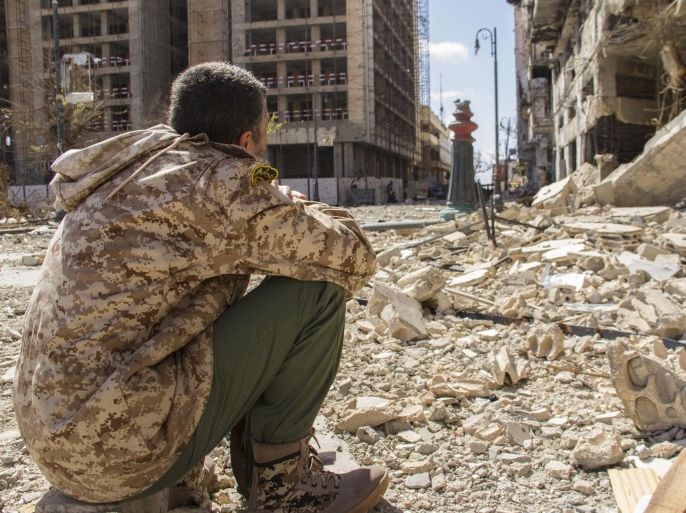 In this photo taken on April 4, 2015, a man looks on at the destruction on a street of the city of Benghazi, Libya. Destruction has permeated the North African country since the civil war ousted Moammar Gadhafi four years ago. For Benghazi, the past year was the worst. (AP Photo/Mohamed Salama)