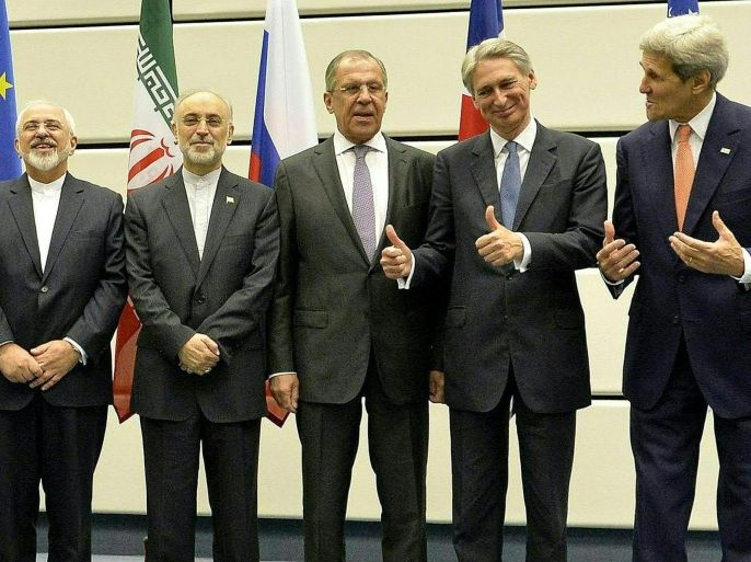 Both US Secretary of State John Kerry (extreme right) and British Foreign Secretary Philip Hammond (second from right) gesture towards Iranian Foreign Minister Mohammad Javad Zarif (extreme left) during a press conference following the conclusion of the E3+3 and Iran nuclear reduction talks, in Vienna 14 July 2015. Also in attendance is Iran's Ambassador to the IAEA Ali Akbar Salehi (second from left) and Russian Foreign Minister Sergei Lavrov (third from left)