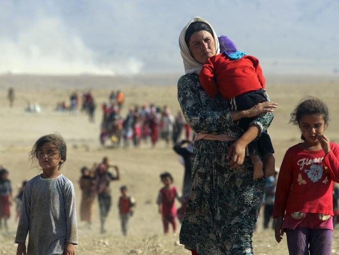 صور تعود إلى أغسطس/آب 2014 يظهر فيها فرار الإيزيديين من تنظيم الدولة بعد هجومه على سنجار (رويترز)
