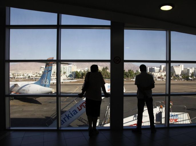 People watch planes land at the airport in the Red Sea resort city of Eilat September 4, 2013. El Al Israel Airlines suspended its daytime service to Israel's southern resort of Eilat on Tuesday, questioning the safety of new flight paths aimed at reducing exposure to potential attacks from militants in nearby Egypt. Picture taken September 4, 2013. REUTERS/Leah Angel (ISRAEL - Tags: TRAVEL MILITARY TRANSPORT)