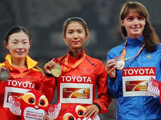 China's Hong Liu (C) poses with her gold medal on the podium after winning the women's 20km Walk race during the Beijing 2015 IAAF World Championships at the National Stadium, also known as Bird's Nest, in Beijing, China, 28 August 2015. Hong Liu won ahead of her second placed compatriot Xiuzhi Lu (L) and third placed Lyudmyla Olyanovska (R) of Ukraine.