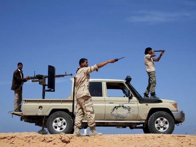 Libya Dawn fighters look at Islamic State (IS) militant positions near Sirte March 19, 2015. Islamic State fighters became a major force last year in Derna, a jihadi bastion in Libya's east, and quickly spread to the biggest eastern city Benghazi, where they have conducted suicide bombings on streets divided among armed factions. By occupying Sirte over the past four months they have claimed a major city in the centre of the country, astride the coastal highway that links the east and west. Picture taken March 19, 2015. REUTERS/Goran Tomasevic/File