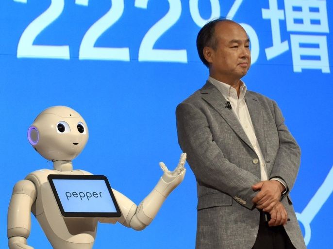 SoftBank Group founder and CEO Masayoshi Son (R) listens to the company's robot 'Pepper' (L) during a press conference announcing the company's financial results in Tokyo on August 6, 2015. Japanese telecommunication company SoftBank Group announced an increase of 175 percent in net profit after the first quarter of the fiscal year 2016, with a 10 percent increase in revenues and non-operating items. AFP PHOTO / TOSHIFUMI KITAMURA