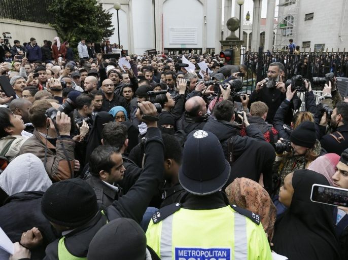 Anjem Choudary, right, a British Muslim social and political activist and spokesman for Islamist group, Islam4UK, speaks following prayers at London Central Mosque in Regent's Park, London, Friday, April 3, 2015. He was opposed by members of the English Defence League and Britain First who were penned in by police across the street from the Mosque. (AP Photo/Tim Ireland)